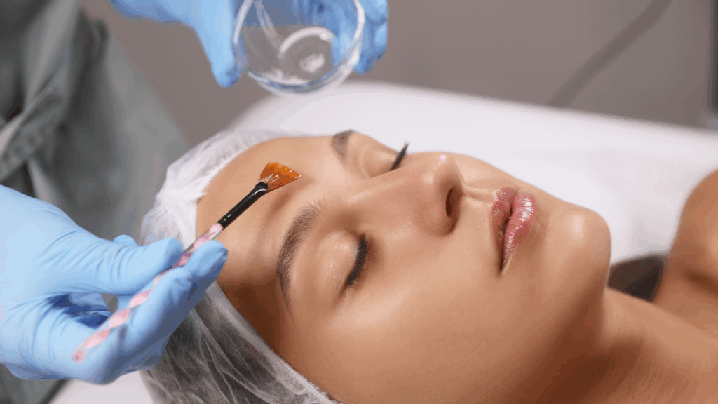Aesthetician applying chemical peeling treatment in Islamabad to woman's forehead with applicator brush